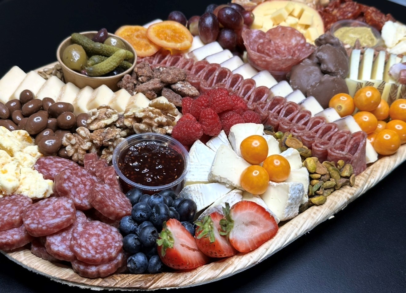 Handcrafted charcuterie board with cured meats, olives, crackers, and seasonal fruits