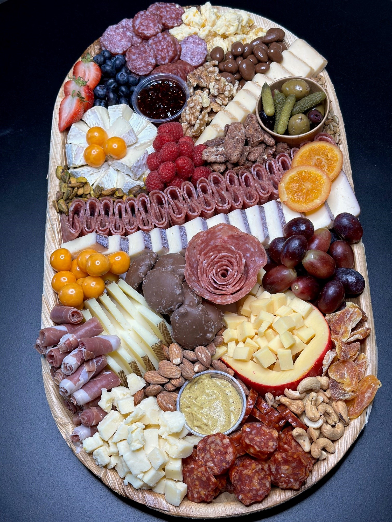 Charcuterie board with chorizo, olives, cheeses, and grapes